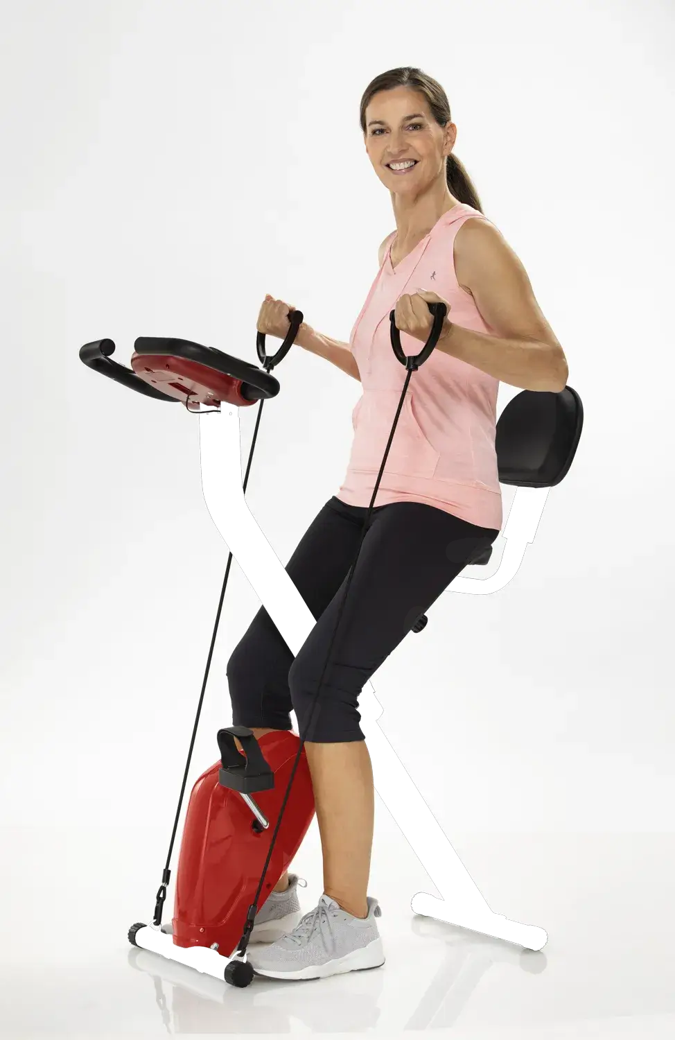 heimtrainer-2in1 klappbarer Ergometer mit Armtrainer für Zuhause, Frau trainiert Beine und Oberkörper sitzend