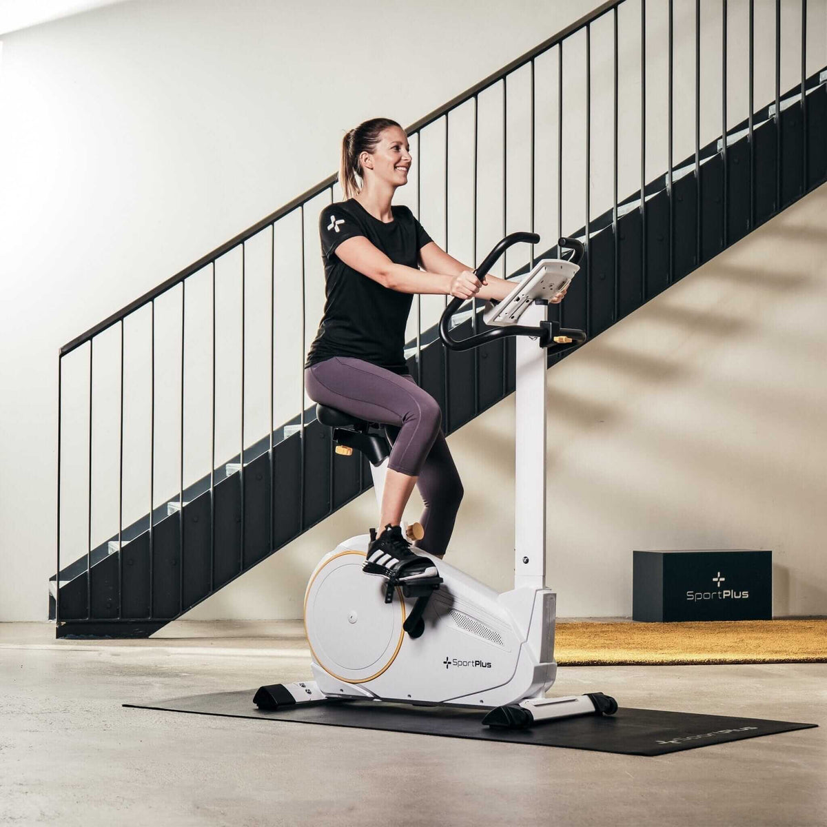 Heimtrainer App kompatibel – Frau trainiert auf Indoor-Bike mit Display, wattgesteuert bis 225 W, stabiler Magnetwiderstand zu Hause