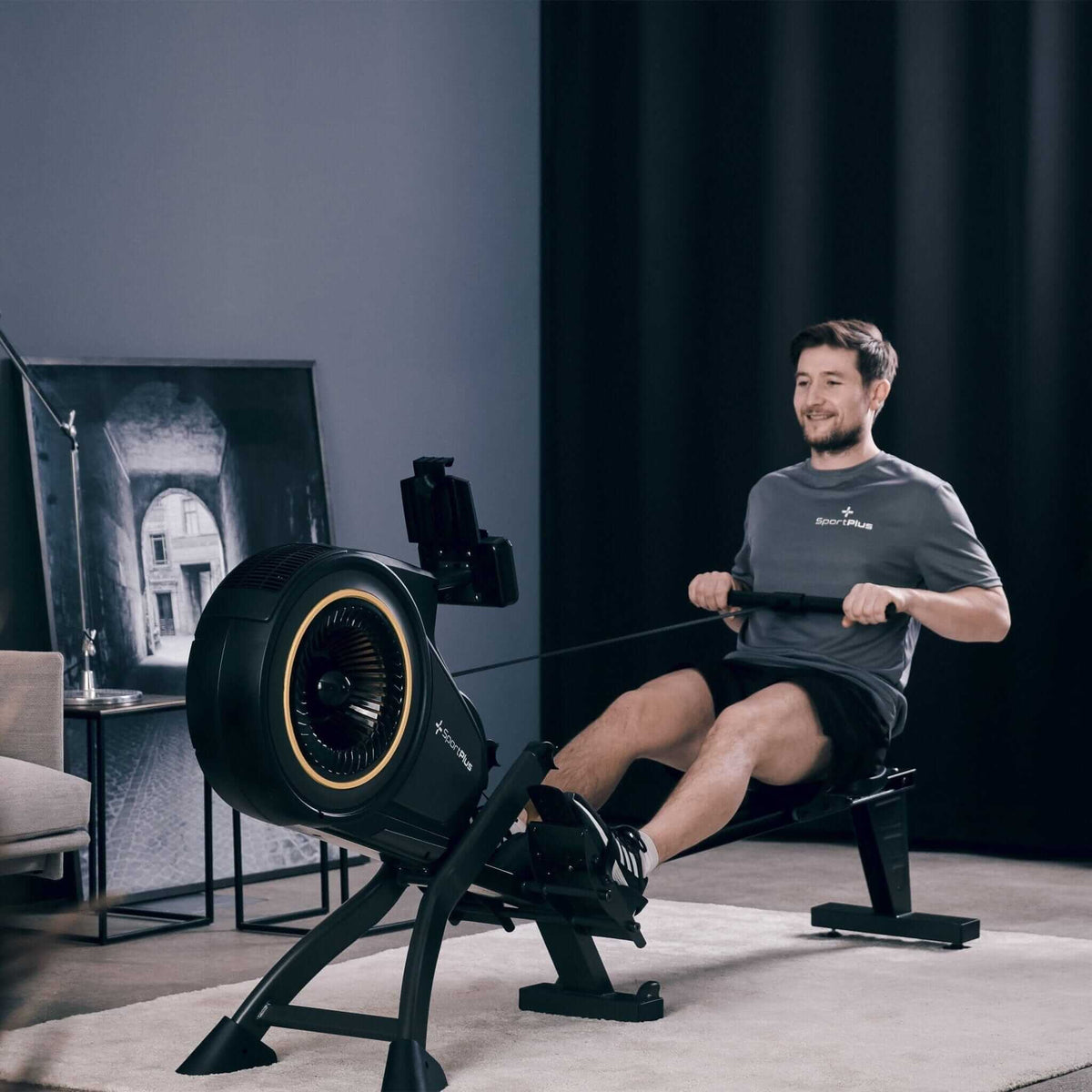 Rudergerät mit Luftwiderstand und App-Kompatibilität im Homegym, Mann beim Rudern am Turbinen-Luftwiderstandsgerät